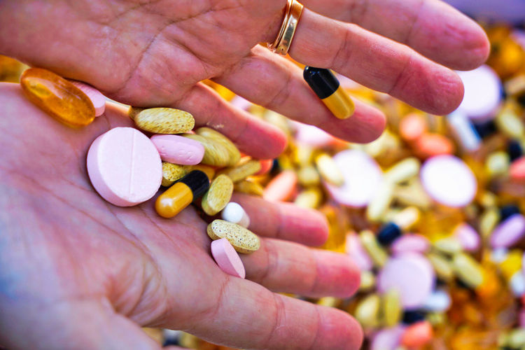 Cropped hand of person holding pills