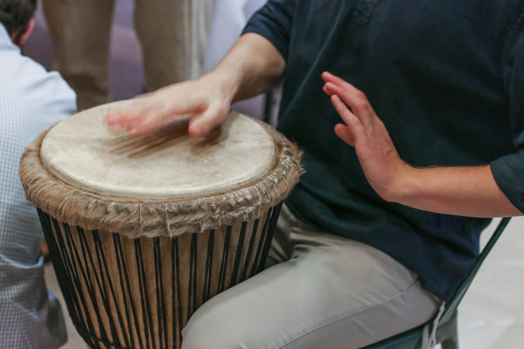 Midsection of man playing percussion instrument