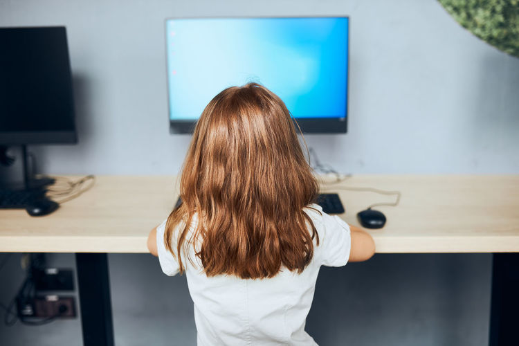 Child learning to use technology in classroom at primary school. student using computer on class