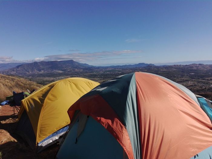 Tent on mountain against blue sky