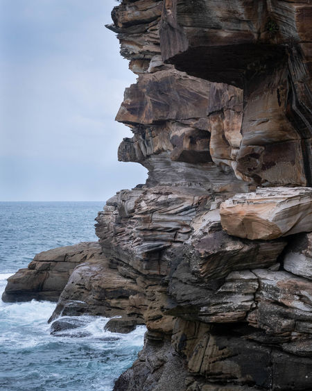 Rock formation in sea against sky