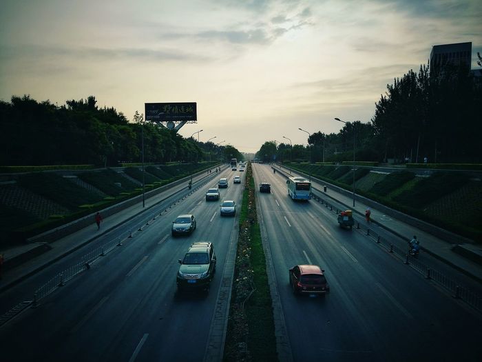 High angle view of cars on highways against sky at dusk