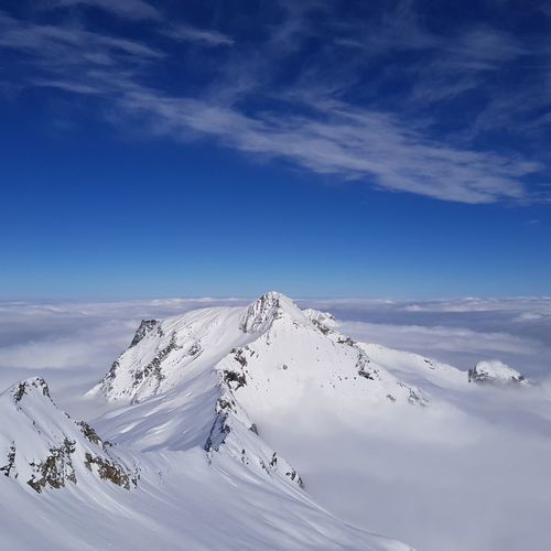 Scenic view of snow mountains against blue sky