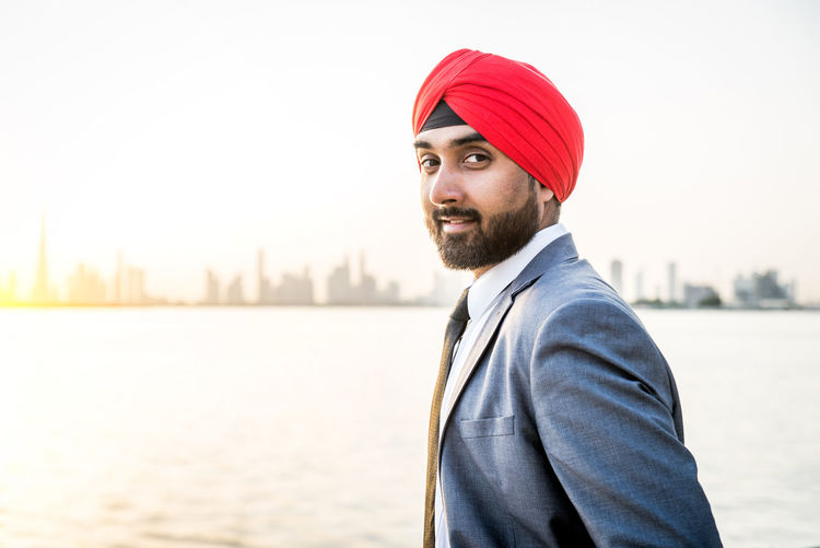 Portrait of businessman wearing turban standing by river