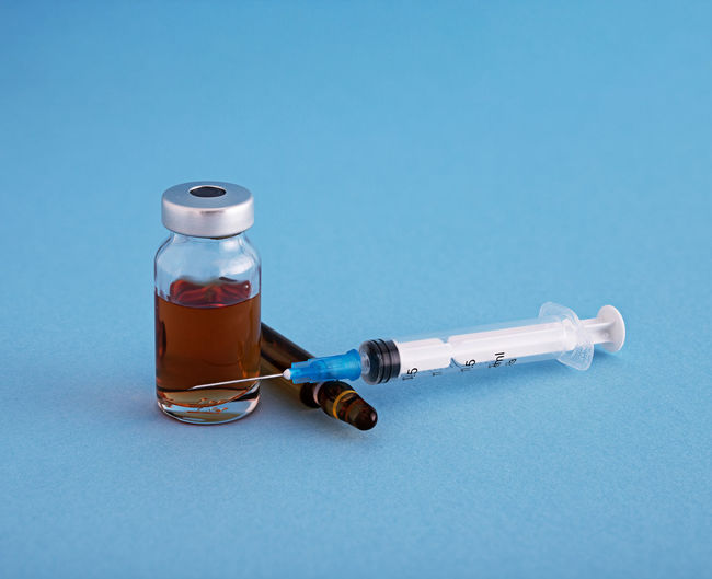 Close-up of bottle on table against blue background