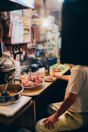 Midsection of person sitting at table in restaurant