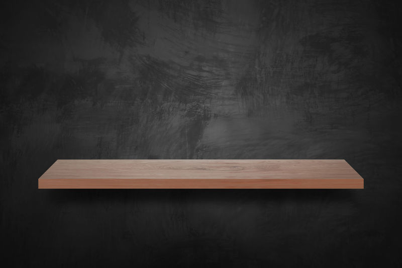 Wooden shelf attached to blackboard