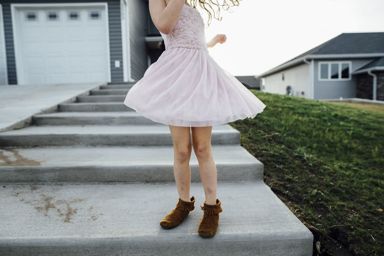 Low section of girl standing on steps in yard