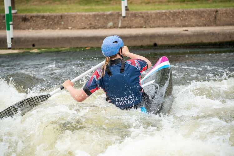 Rear view of man surfing on water