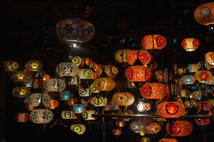 Illuminated lanterns hanging at market stall