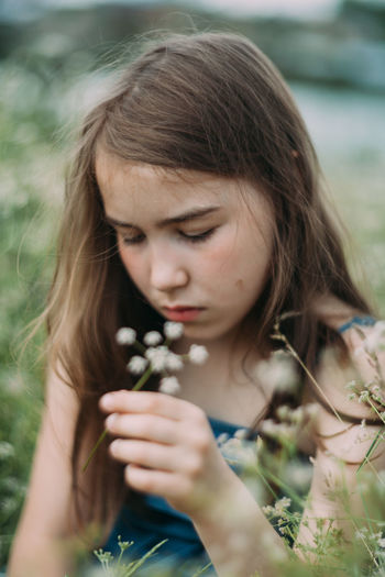 Cute girl smelling flowers outdoors