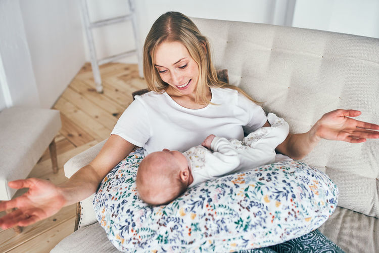 High angle view of smiling mother with baby at home