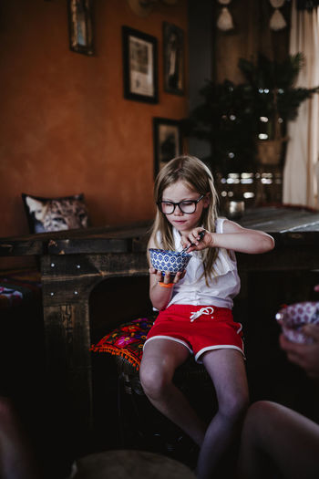 Girl holding bowl and eating