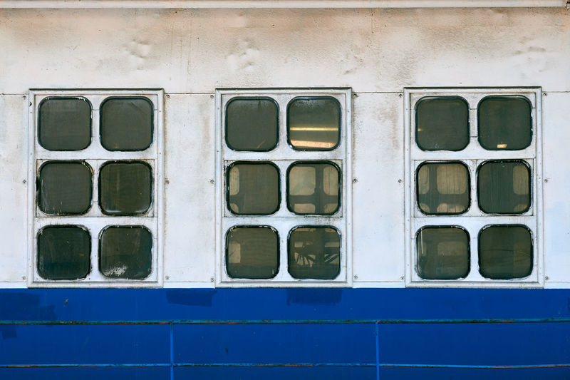 Cabin windows and portholes on outboard side of ship. close up of hull of vintage ocean liner