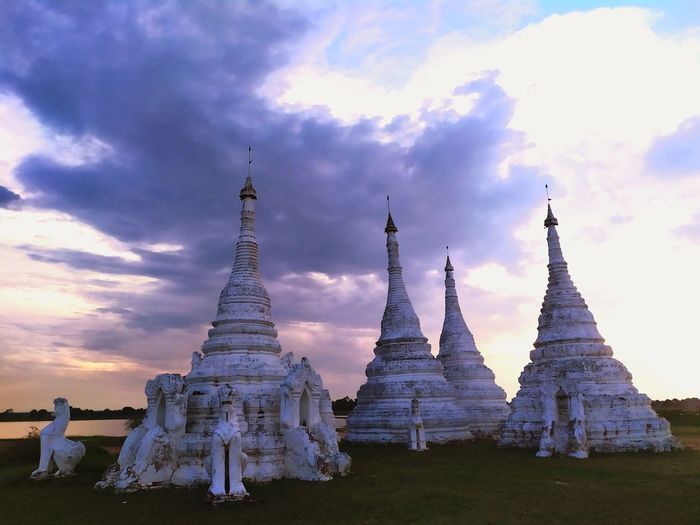 Stupas of building against cloudy sky