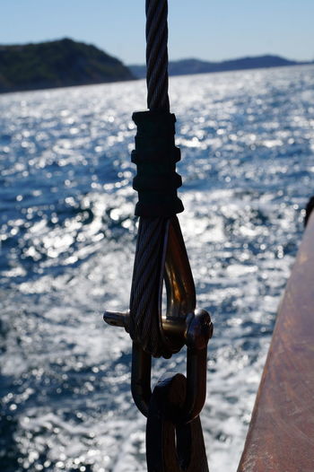 Close-up of rope tied to boat against sea