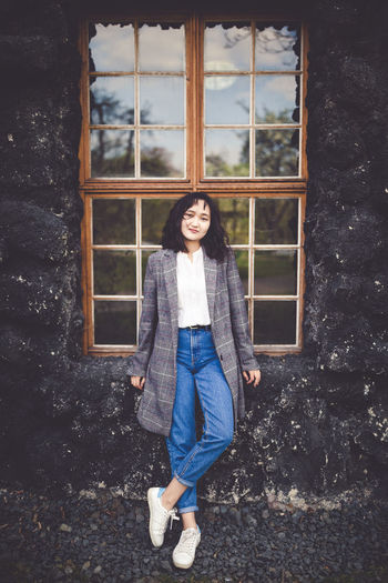 Confident asian woman in front of rustic building at countryside, outdoor portrat. spring or fall
