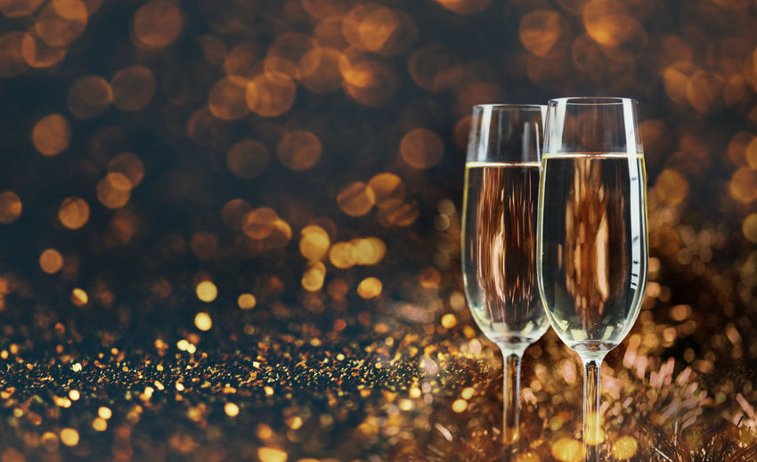 Close-up of champagne flutes on glitters