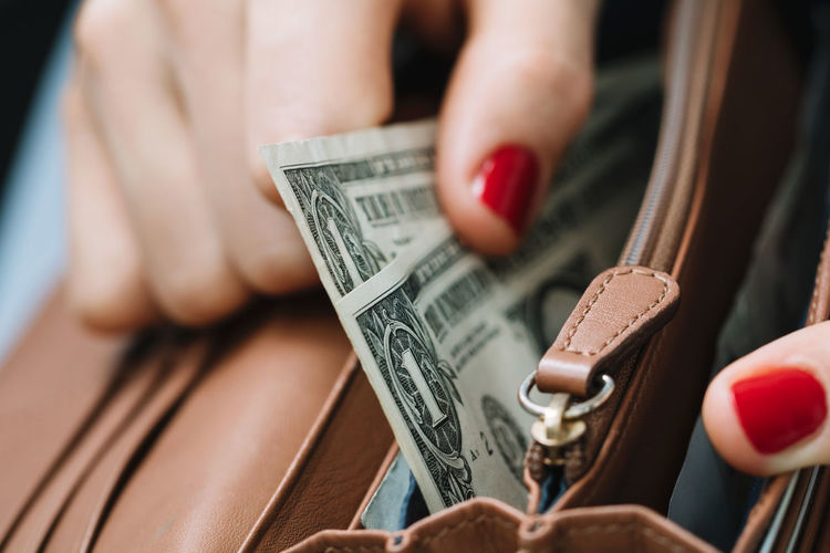 Close-up of woman holding dollar bills