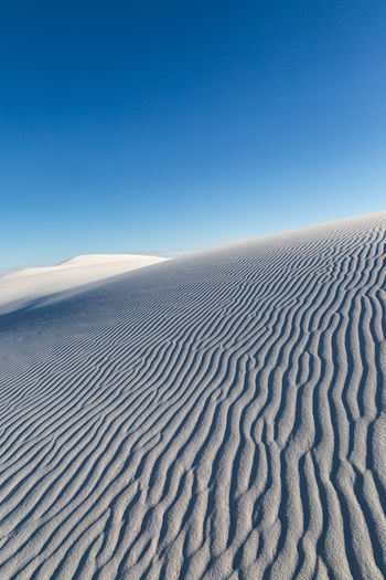 Ripples in sand, at white sands national park, with a blue sky overhead