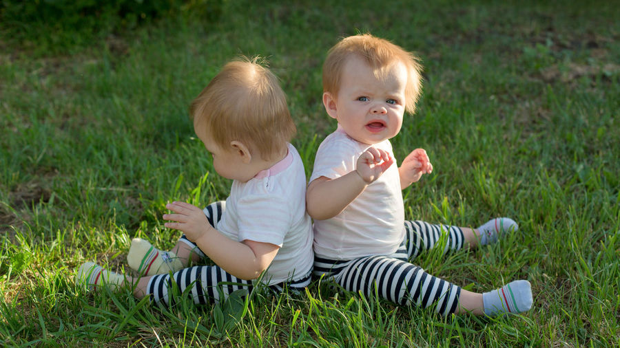 Siblings sitting on field