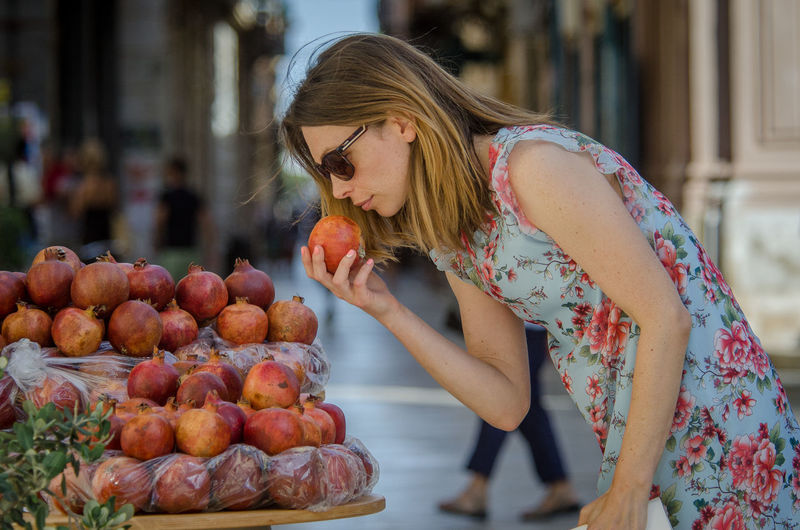 Woman smelling pomegranate in market