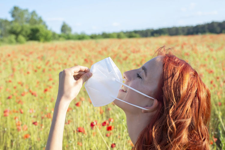 Rear view of woman drinking water on field