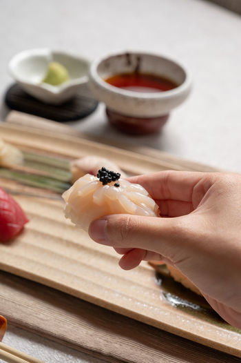 Cropped hand of person preparing food on table