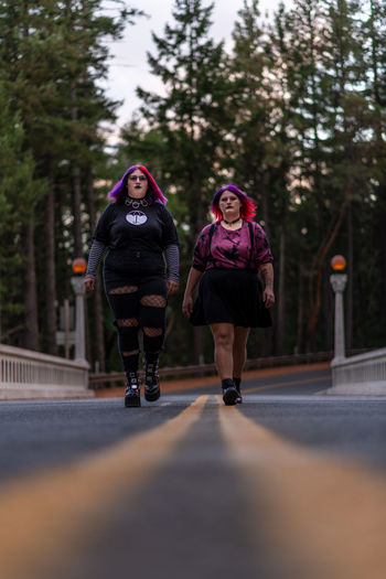 Beautiful gothic women walking on road
