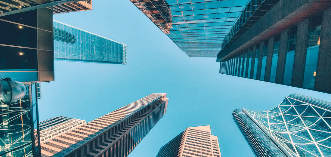 Low angle view of modern buildings against clear blue sky