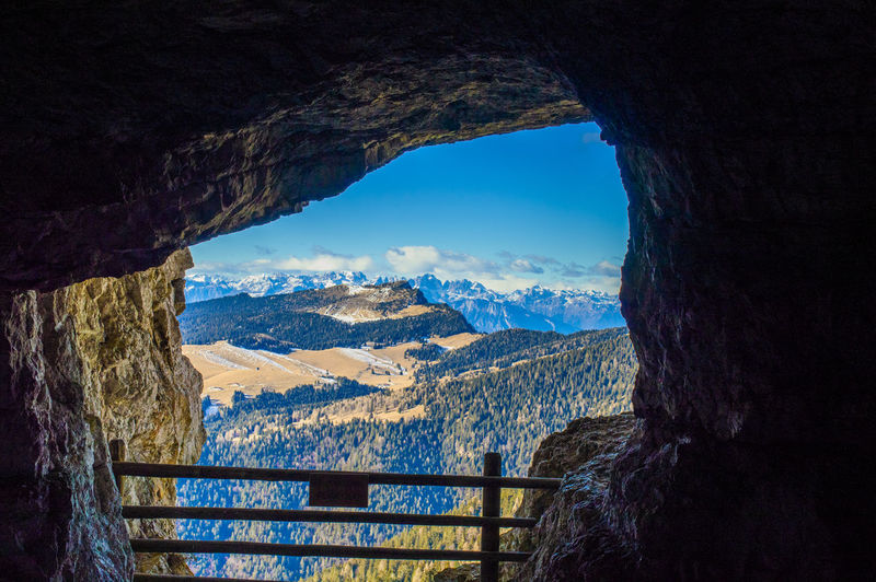 Scenic view of mountains against sky seen through cave