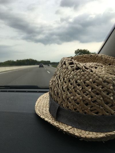 Close-up of hat on car windshield against sky