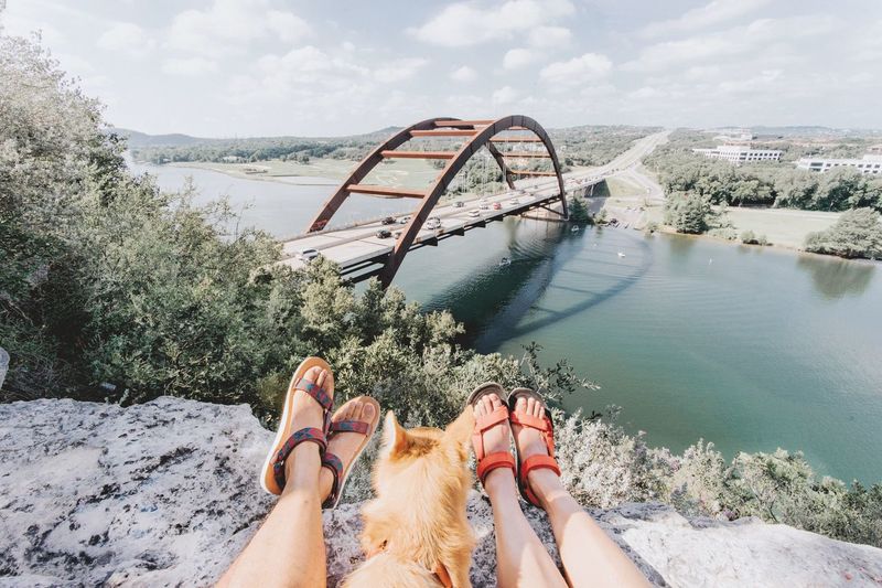 Low section of women with dog on mountain against river