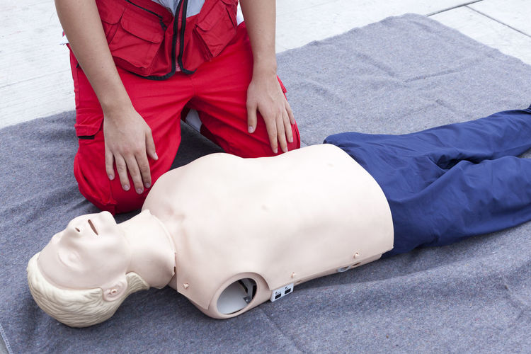 Low section of paramedic with cpr dummy on blanket