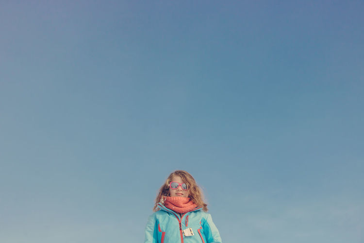 Portrait of girl against blue sky