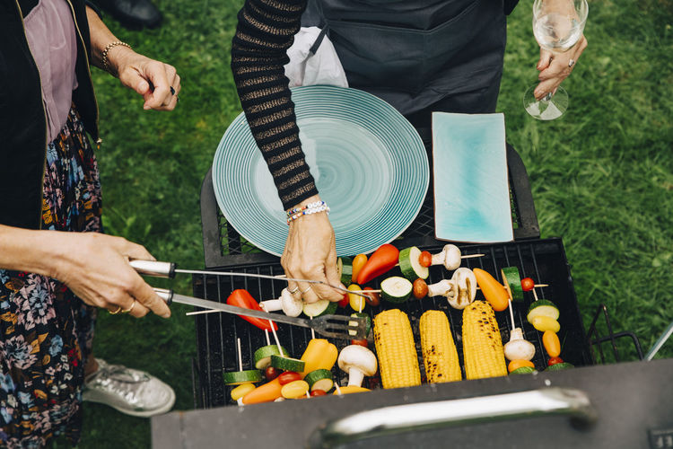 High angle view of women barbecuing vegetables at garden party