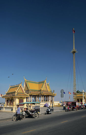 Cars on street against clear blue sky