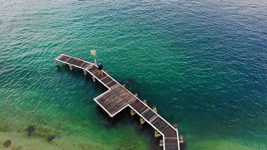 High angle view of man walking on pier over sea