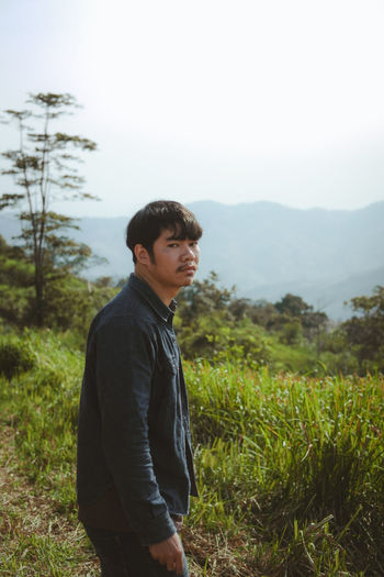 Side view of young man standing on field