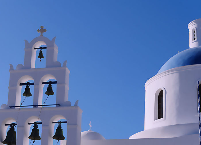 Low angle view of bell tower against clear blue sky