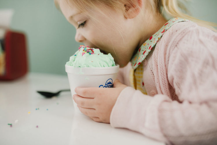 Girl taking a big bite of her green ice cream