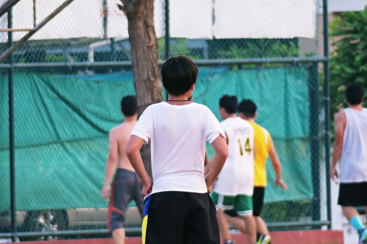 Rear view of people playing on court