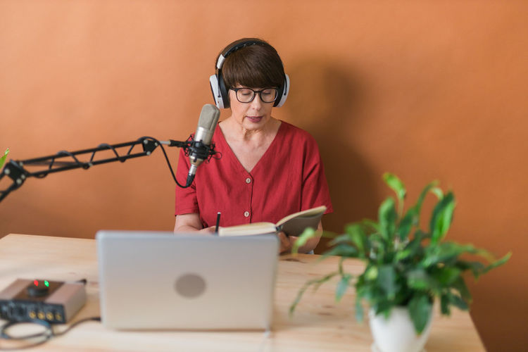 Female journalist podcasting at home