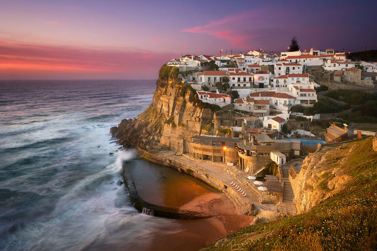 Scenic view of azenhas do mar by sea against sky
