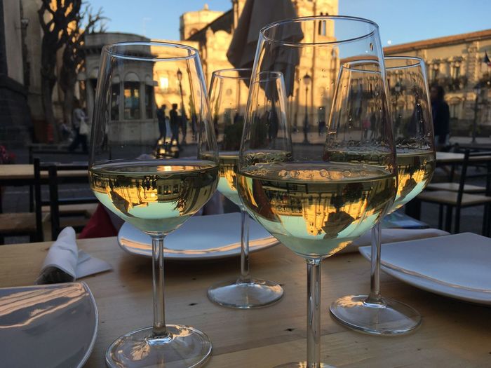 Close-up of white wine in wineglasses on table in city