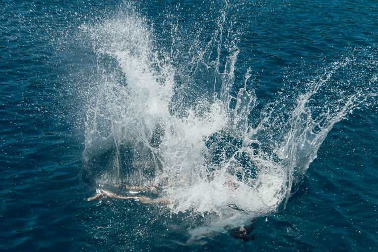 High angle view of a person splashing into the water or ocean.