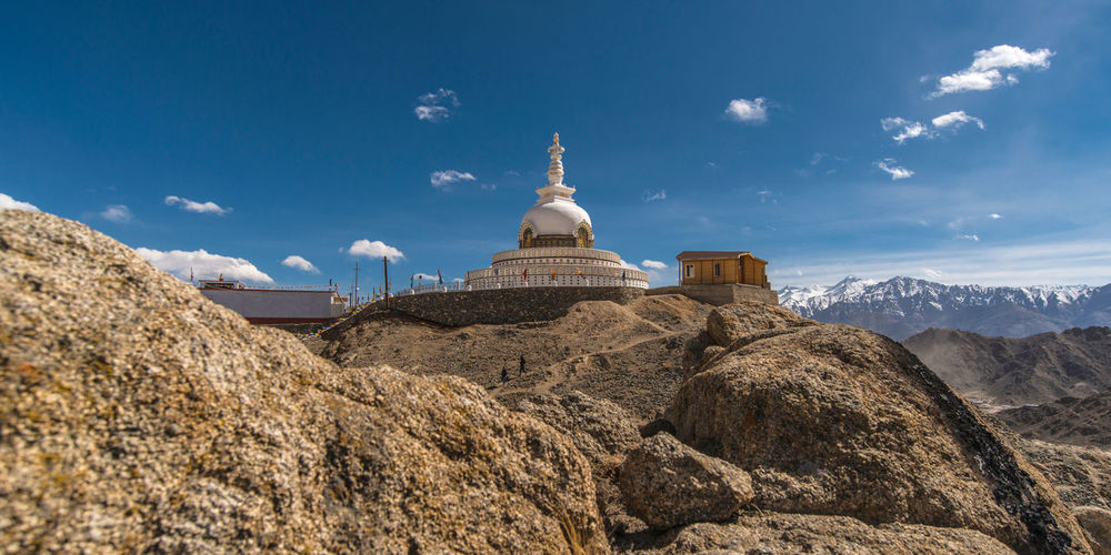 Low angle view of temple on mountain against blue sky
