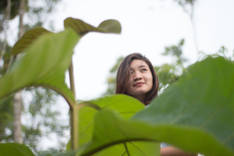 Portrait of woman against blurred plants