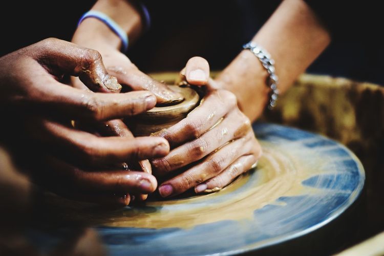 Close-up of hands working on pottery wheel