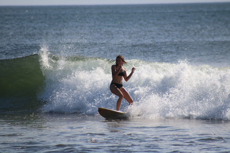Young woman surfing in sea